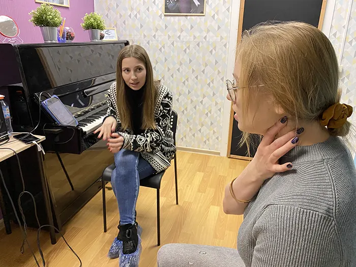 Подросток на занятии вокалом, педагог рядом