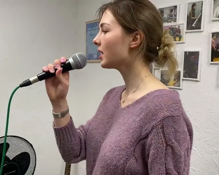 Ученица поёт у микрофона на занятии